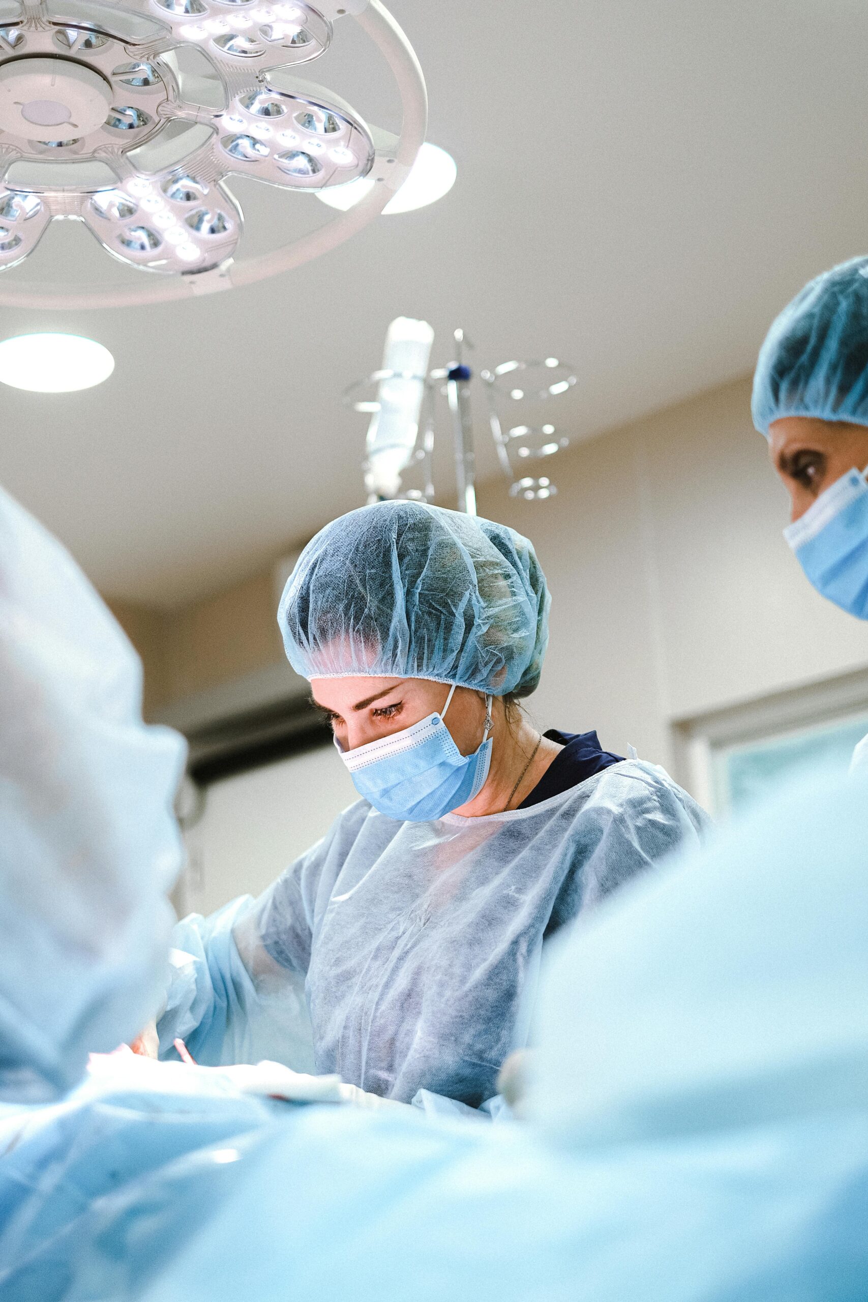 A team of surgeons and nurses in protective gear performing an operation in a hospital.